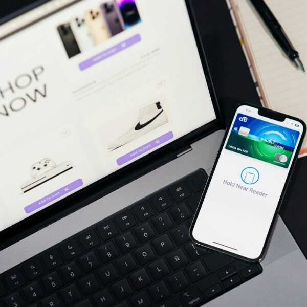 A cell phone sitting on top of a desk next to a laptop