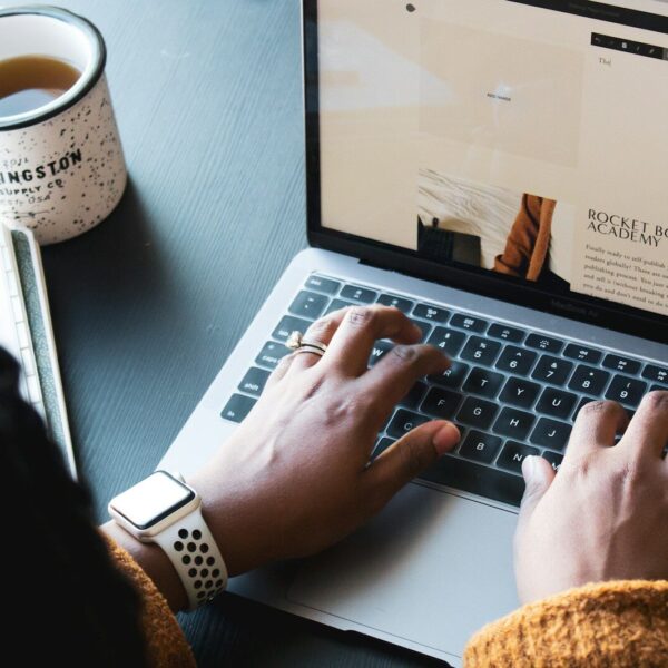 Person using macbook pro on black table
